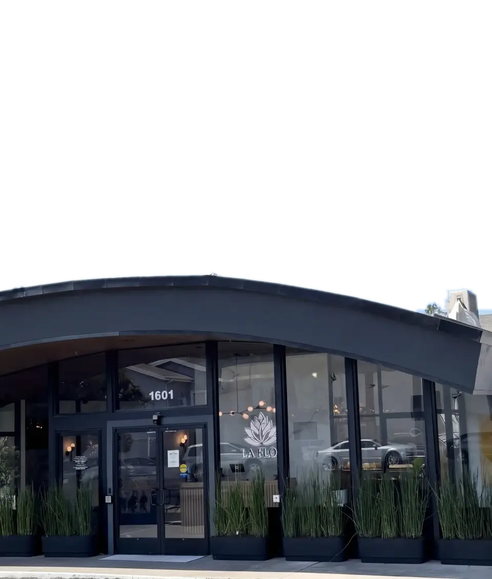 La Flōr by day on Sir Francis Drake Boulevard in Fairfax: the curved canopy over the glass front and the lotus logo in the window.