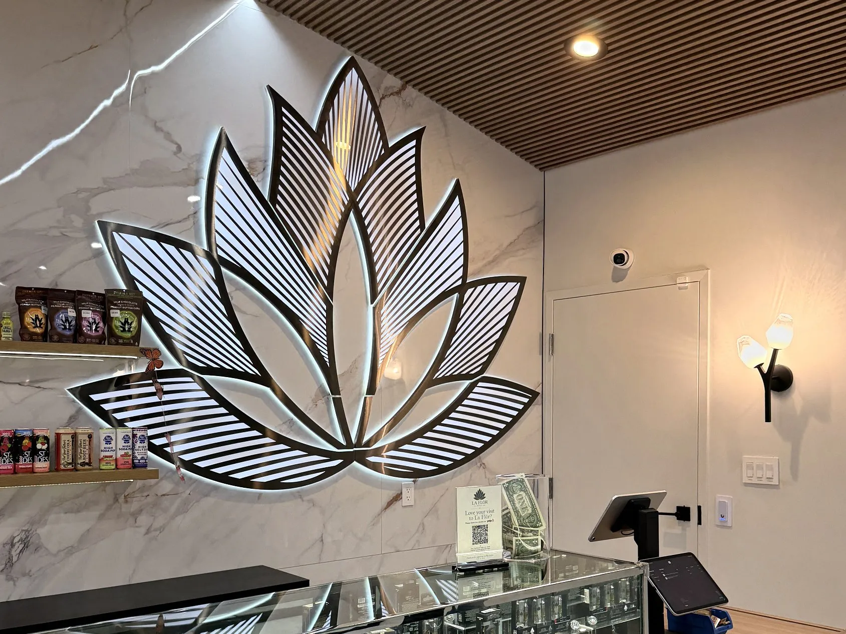 The lit metal lotus sculpture on the marble wall above the end of the counter.